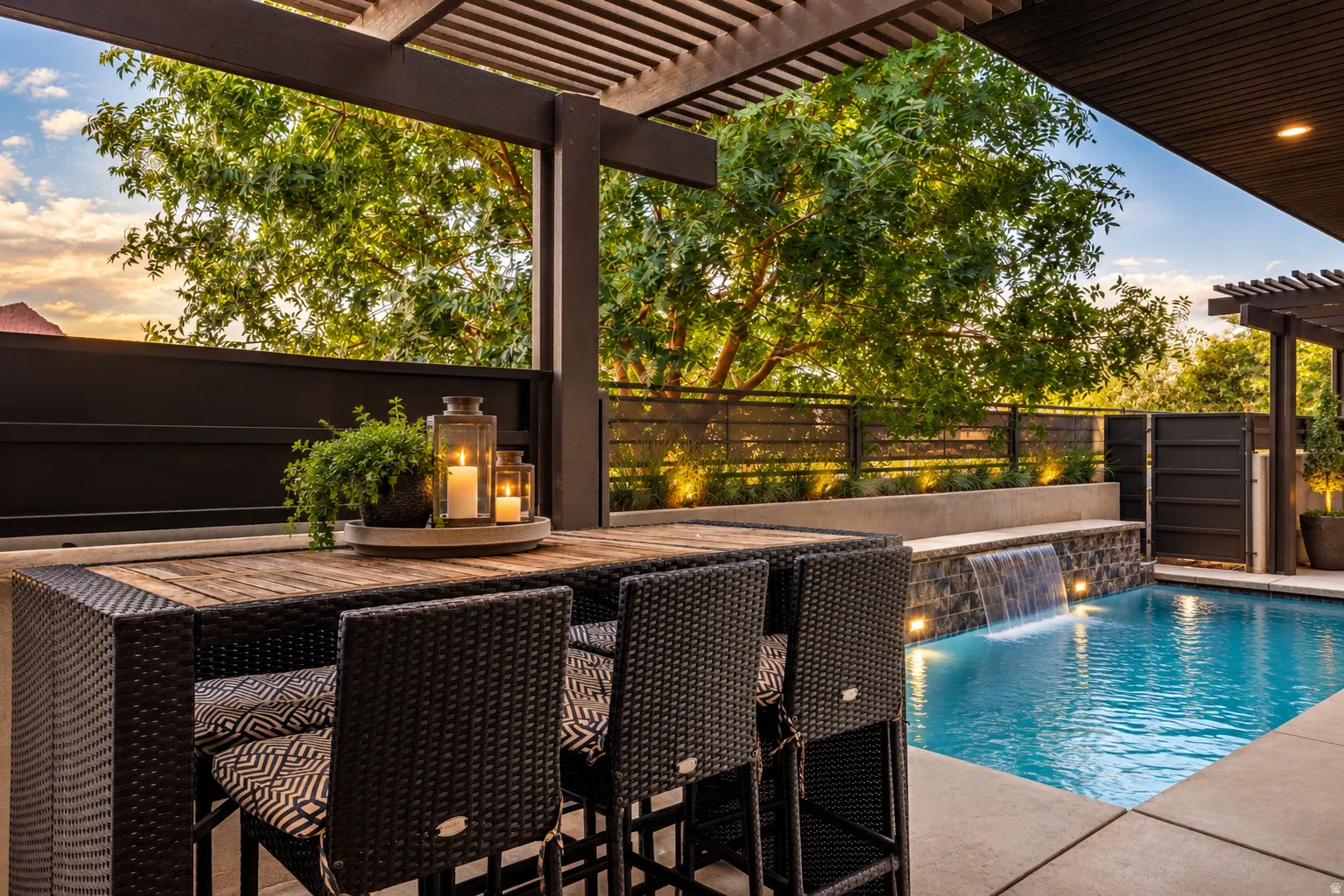 Patio featuring a slatted pergola, integrated lighting, a pool with a water feature, and a privacy fence