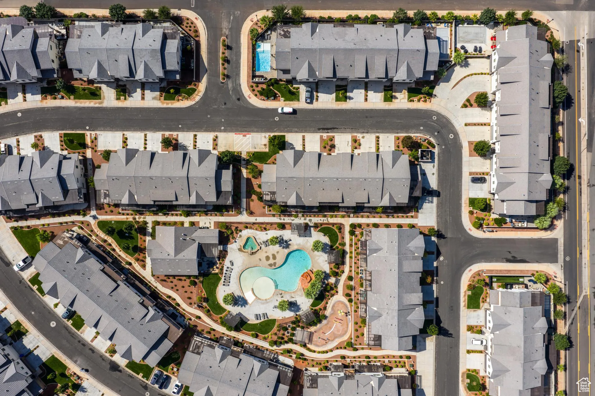 Aerial view of property and surrounding area with a pool area and nearby suburban area