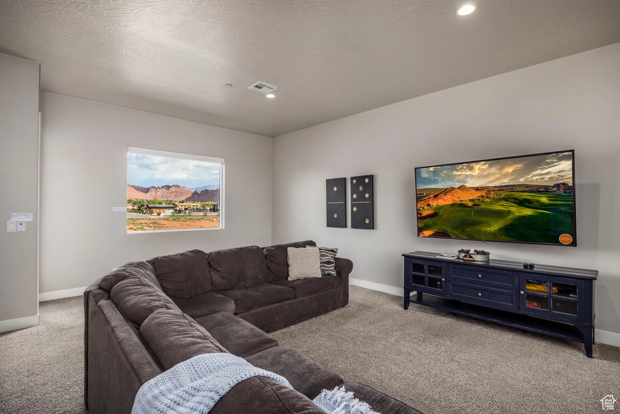 Living area with carpet flooring and a textured ceiling