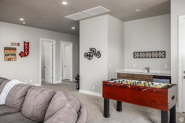 Rec room with carpet floors, a textured ceiling, and recessed lighting