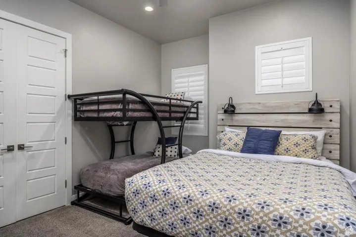 Bedroom with carpet flooring, a closet, and a ceiling fan
