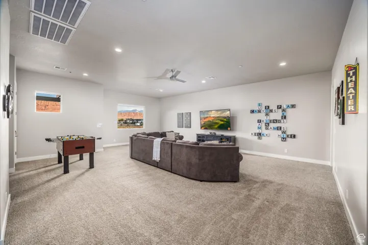 Living room featuring light carpet, a ceiling fan, and recessed lighting