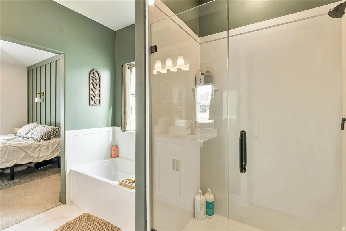 Ensuite bathroom with a bath, a shower stall, and vanity