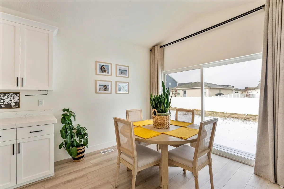 Dining area featuring light wood-style floors and vaulted ceiling