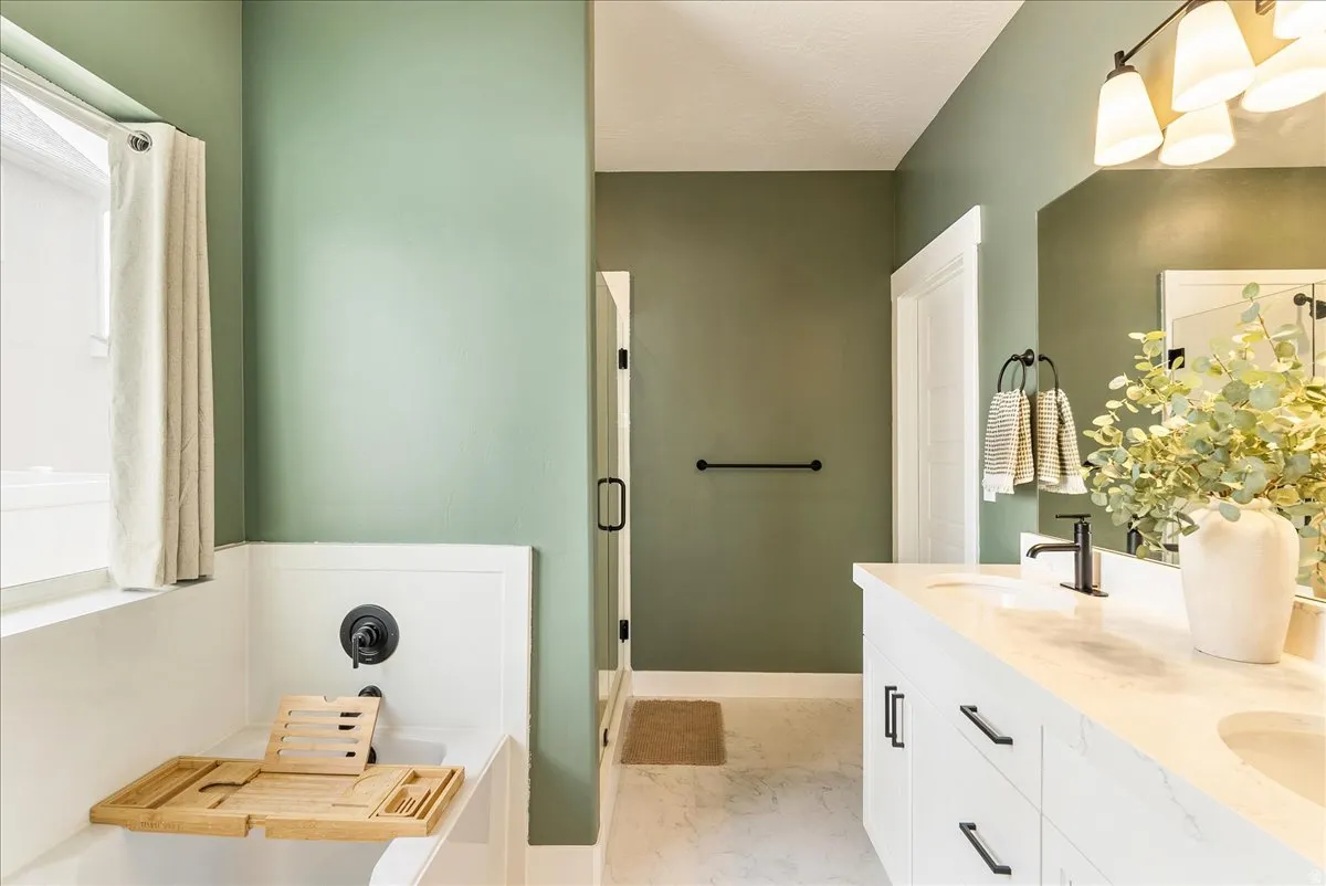 Full bathroom with a garden tub, double vanity, and light marble finish floors