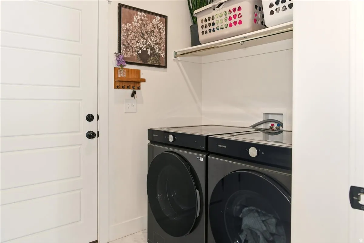 Washroom with washer and clothes dryer and baseboards