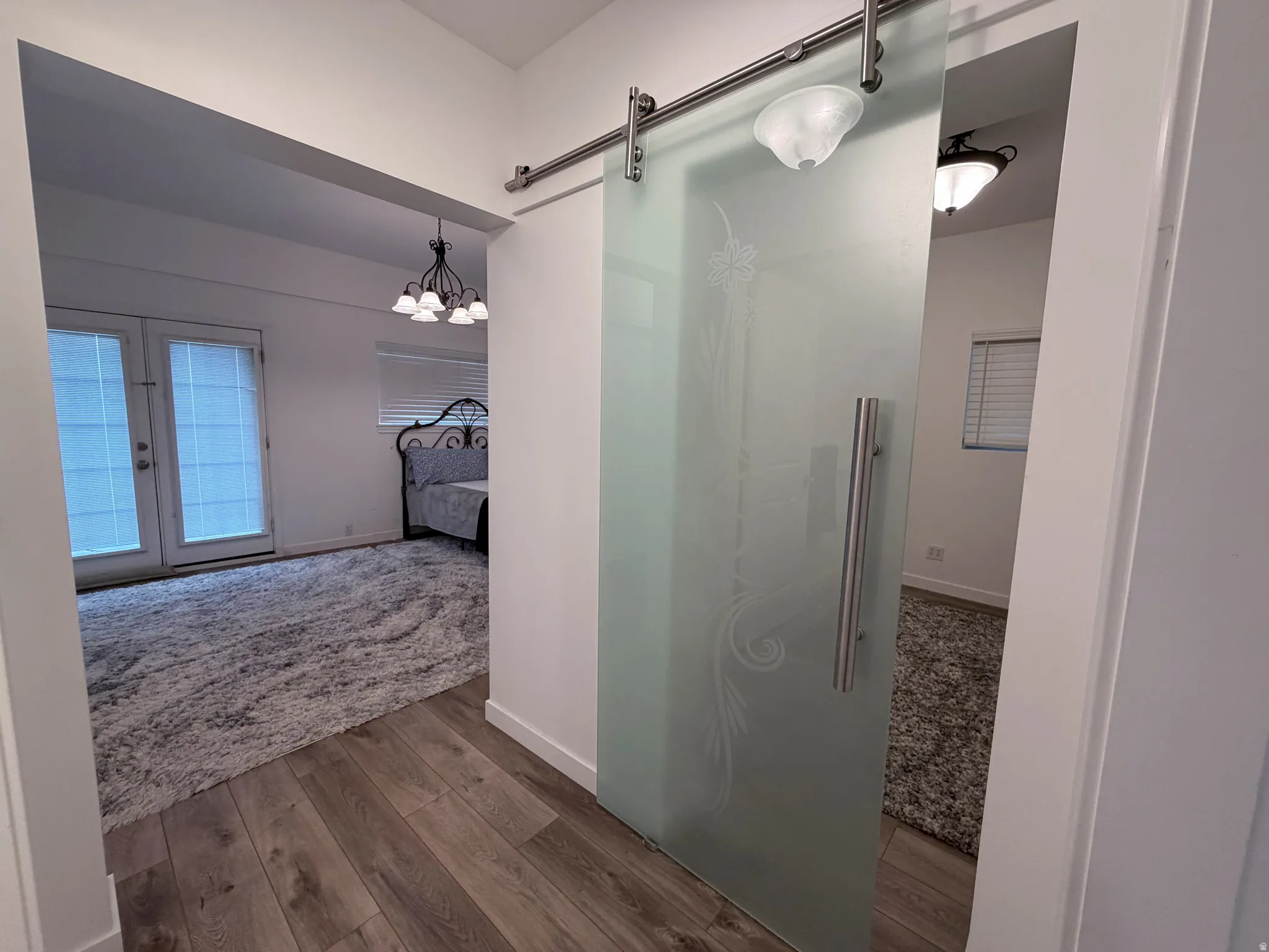 Ensuite bathroom with dark wood-type flooring, a walk in shower, and suspended lighting