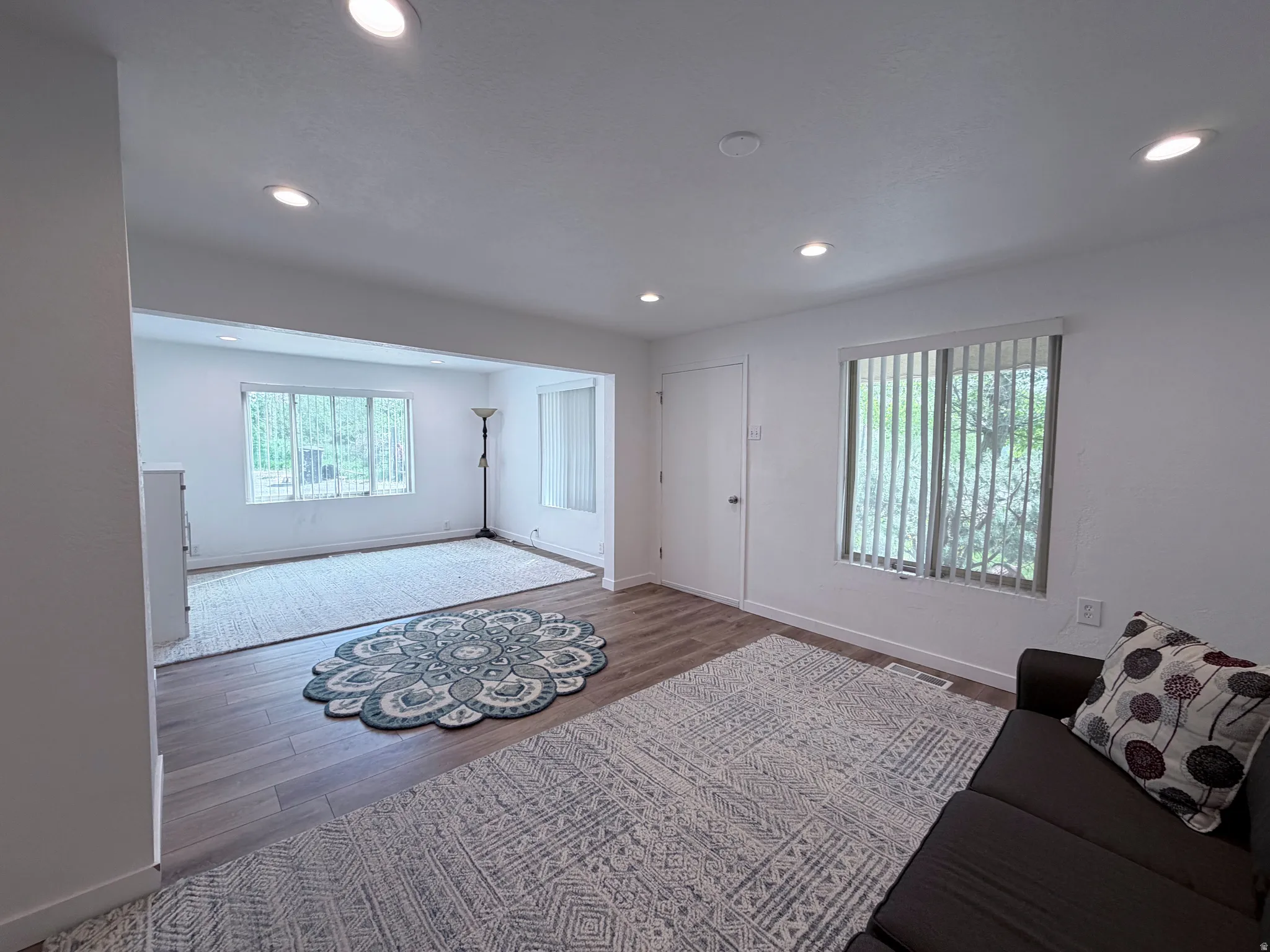 Living room with dark wood finished floors and recessed lighting
