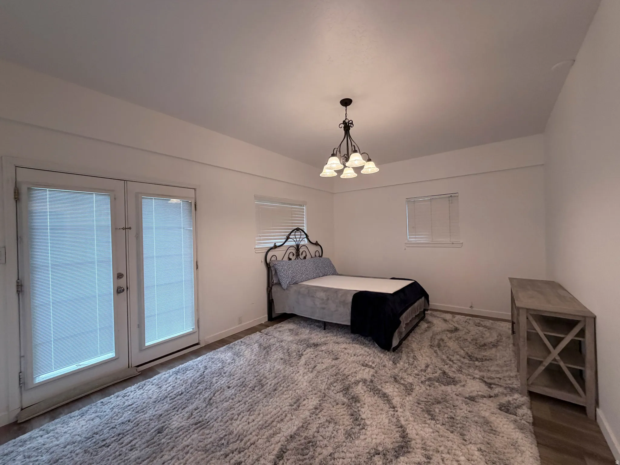 Bedroom with access to outside, a chandelier, and french doors