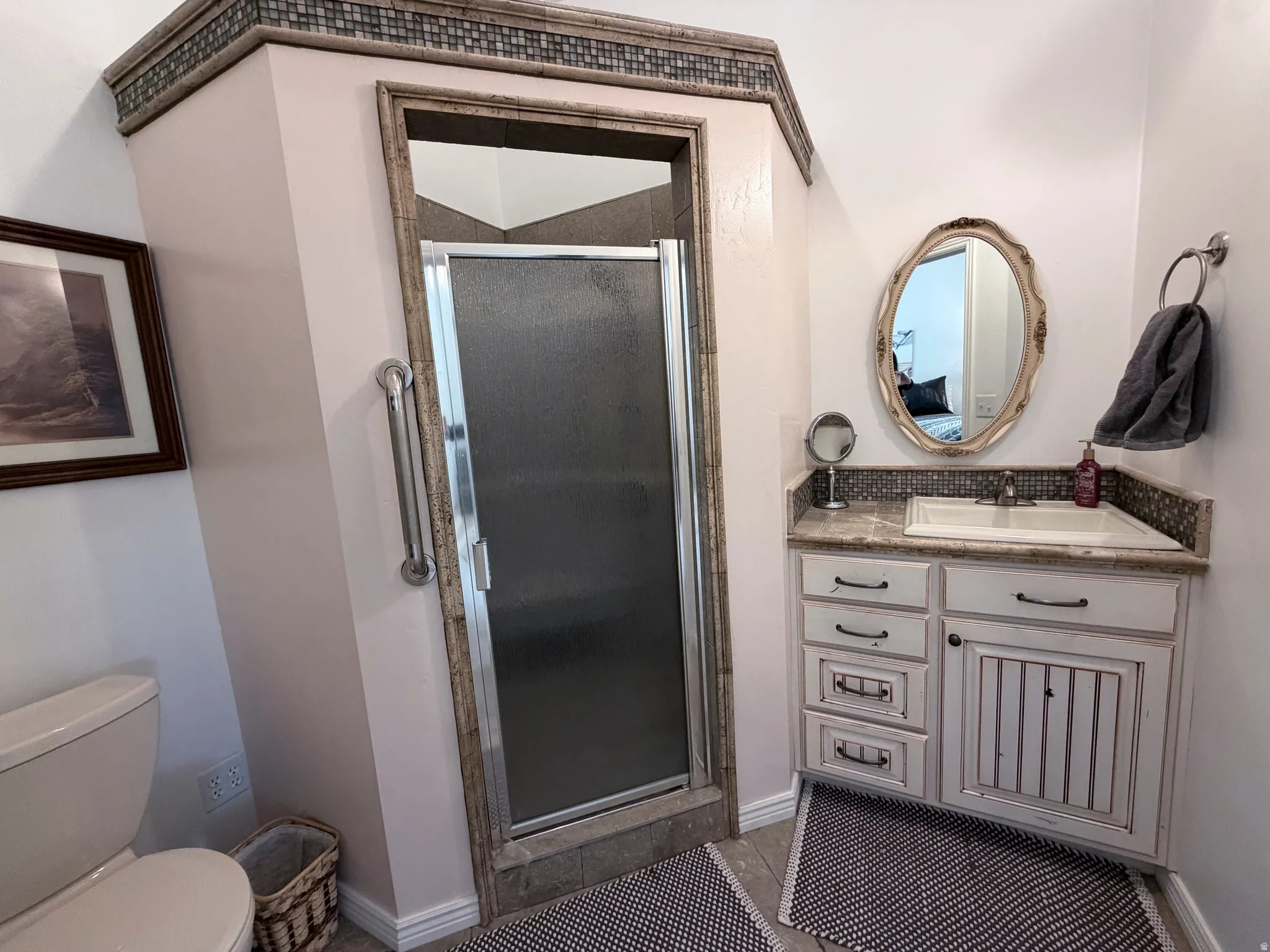 Bathroom with vanity, a stall shower, and light tile patterned floors