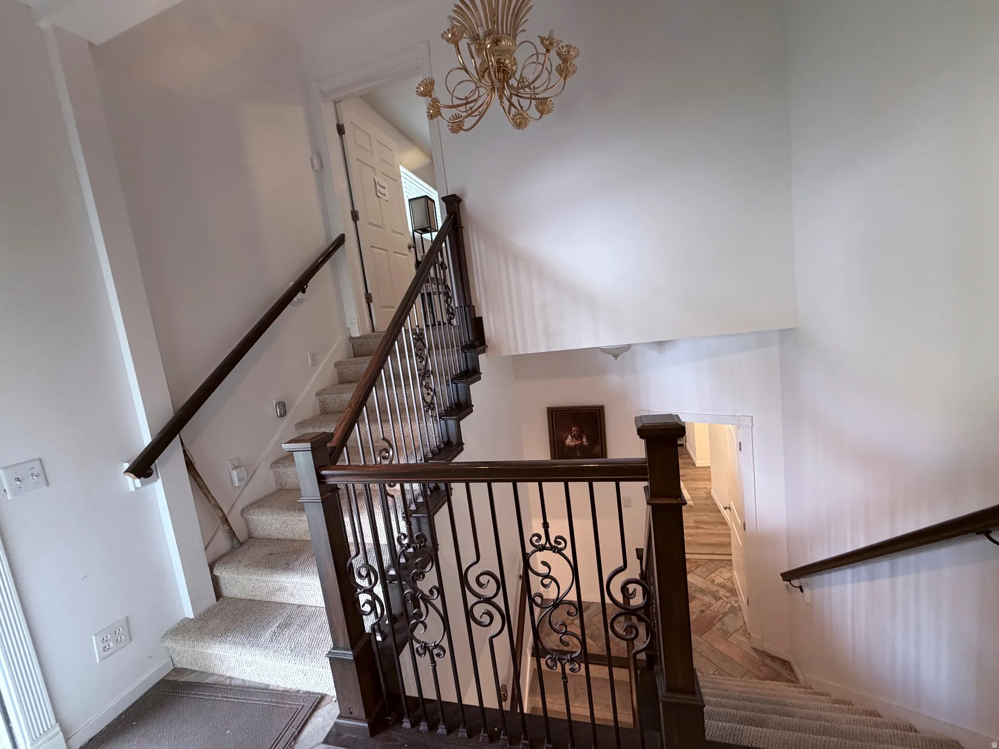 Staircase featuring a high ceiling, a chandelier, and carpet flooring