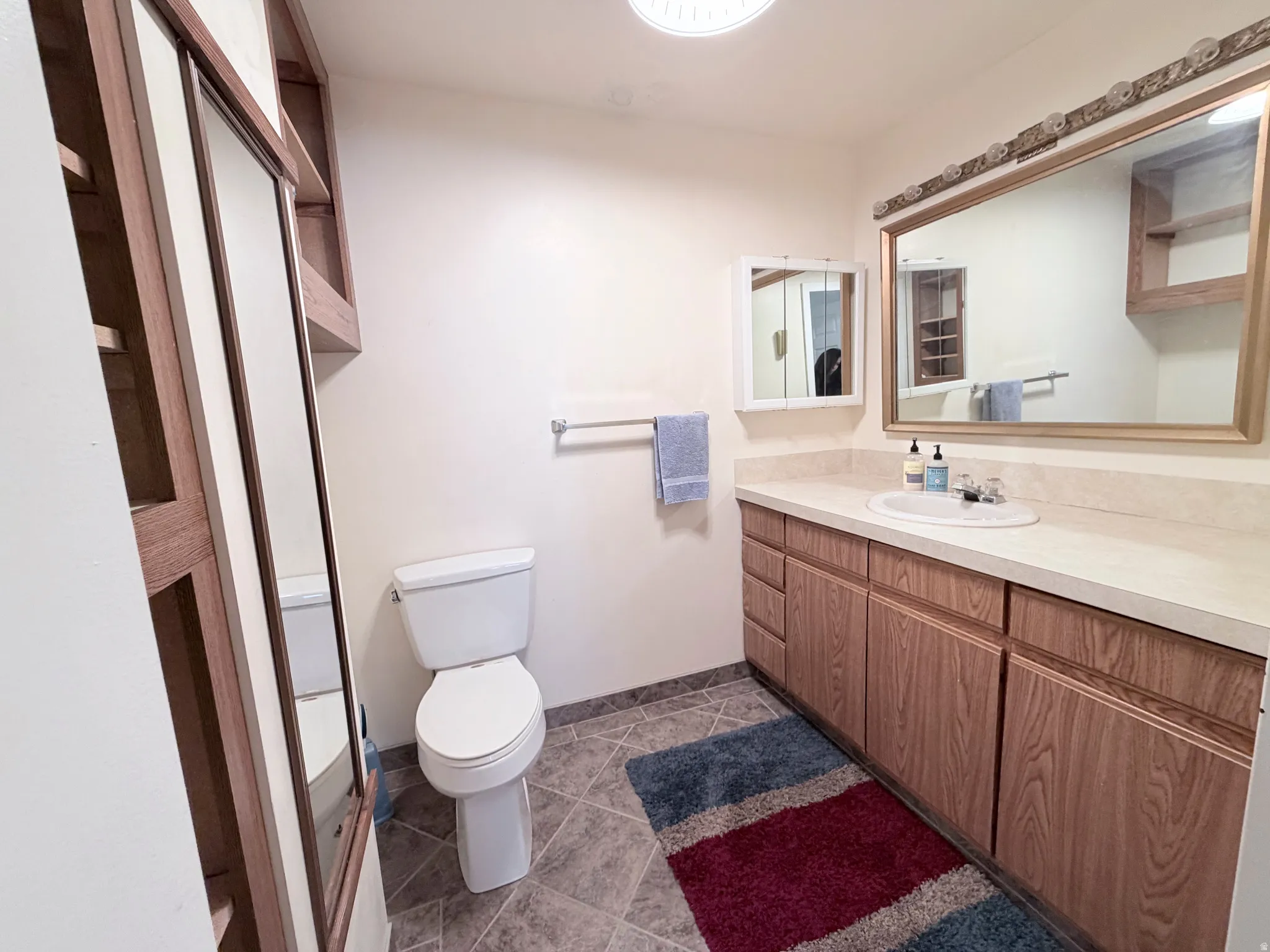Bathroom featuring vanity and dark tile patterned flooring