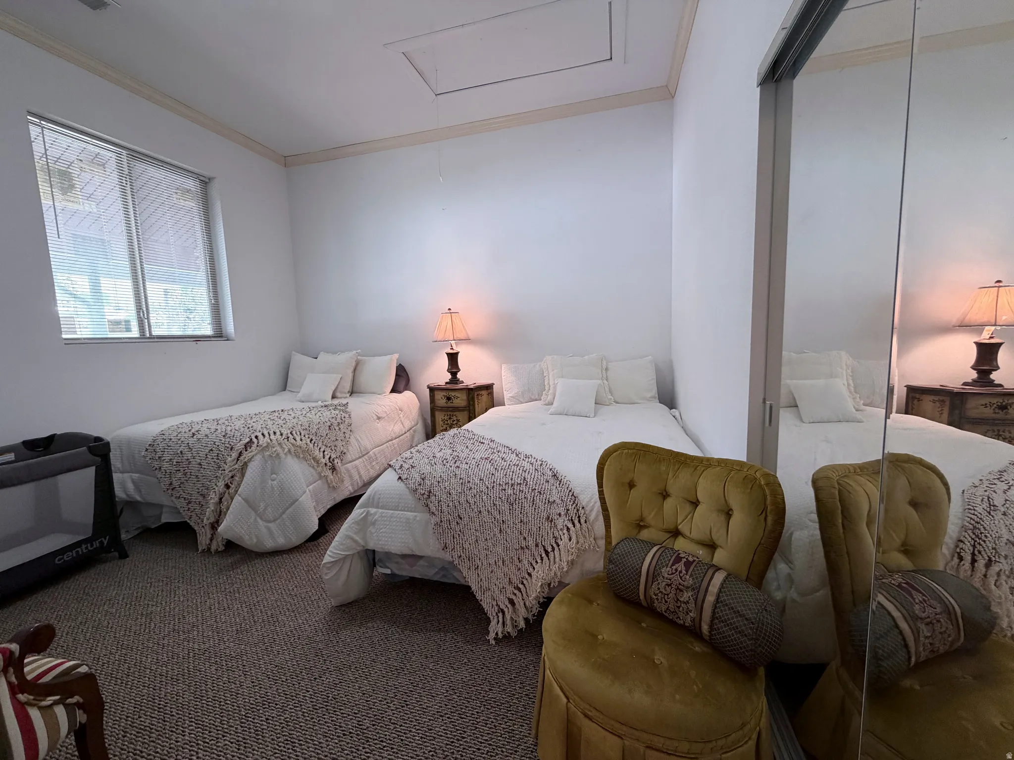 Carpeted bedroom featuring crown molding and attic access