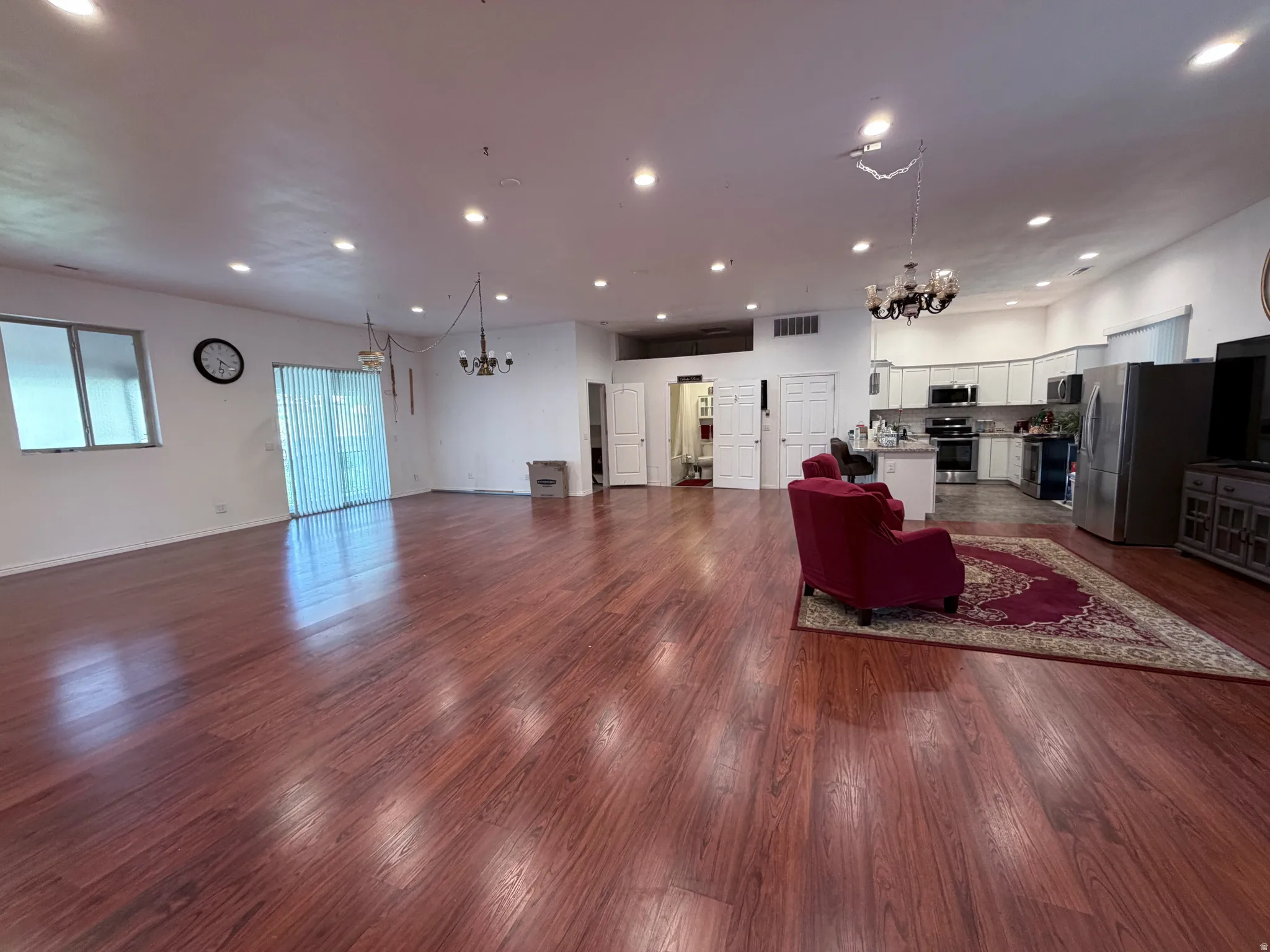 Living area with suspended lighting and dark wood finished floors