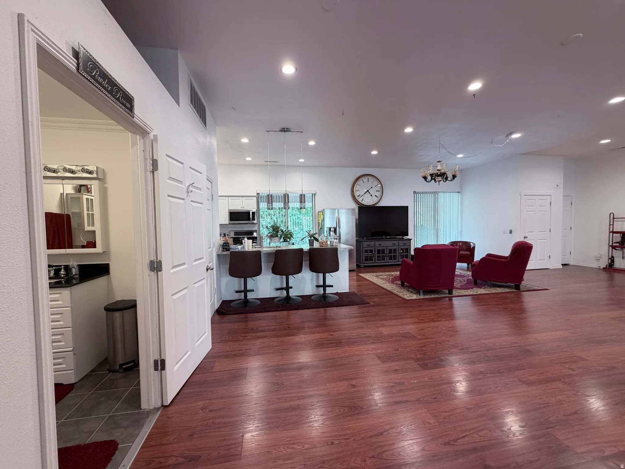 Living area with dark wood-style flooring and hanging lights