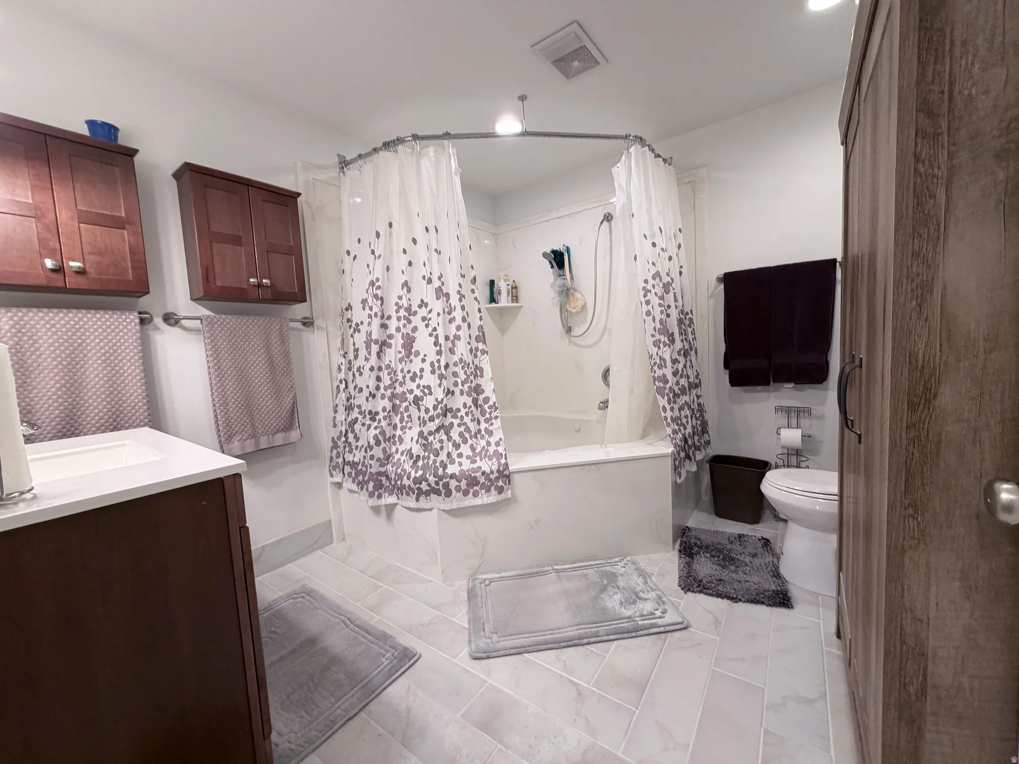 Full bath featuring shower / bath combination with curtain and vanity