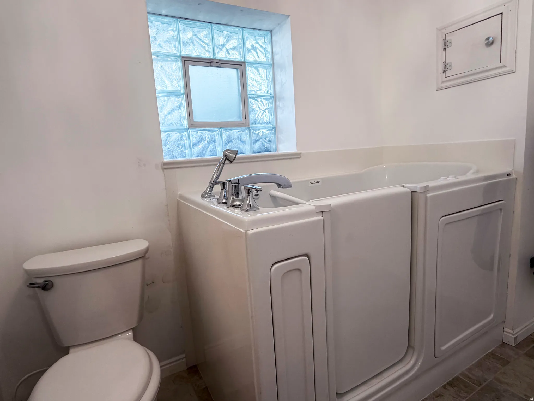 White walk-in tub with chrome fixtures and an integrated handheld showerhead