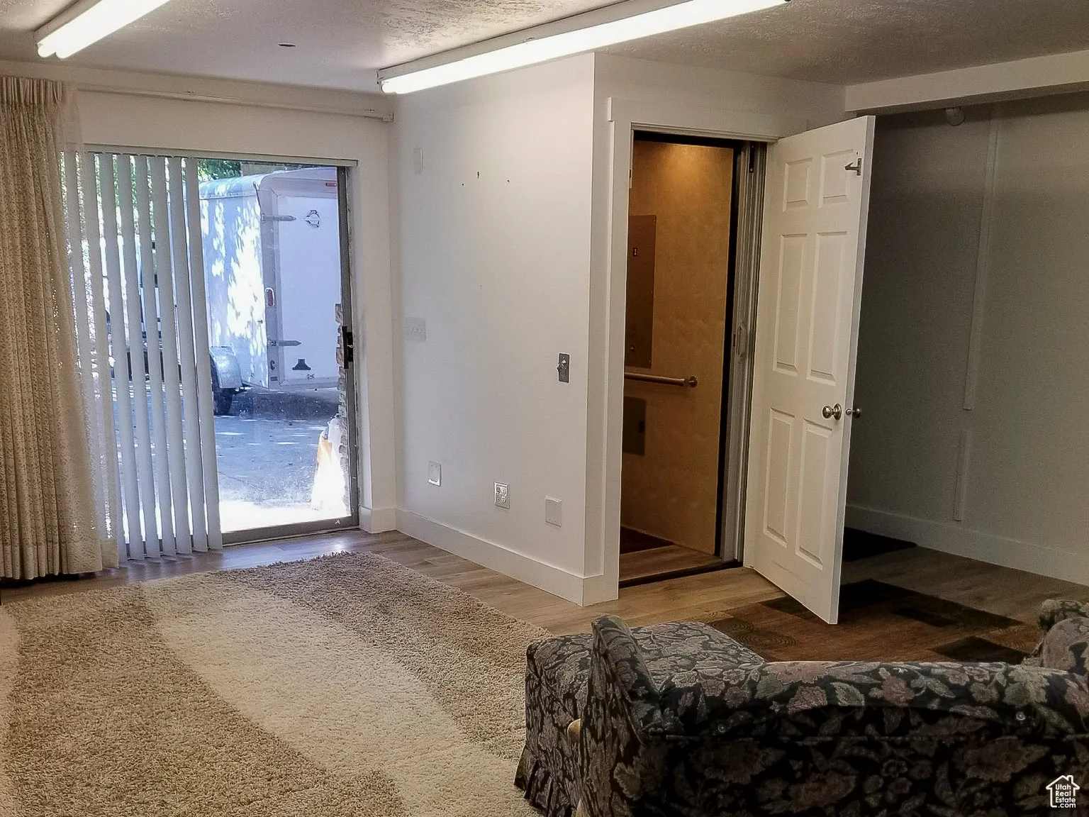 This unfurnished room features hardwood floors and access to the outdoors.