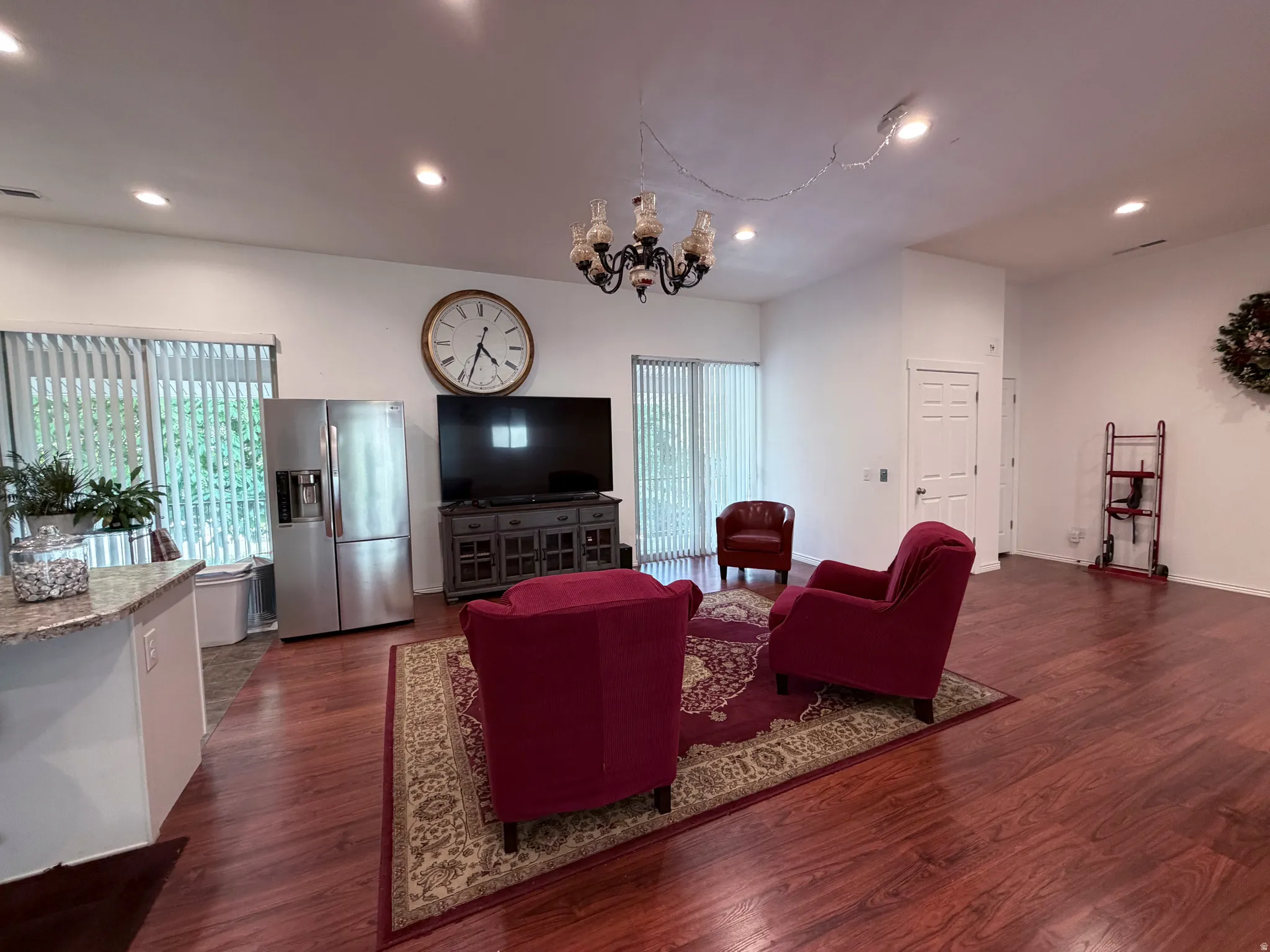 Living area with dark wood-type flooring and hanging lights
