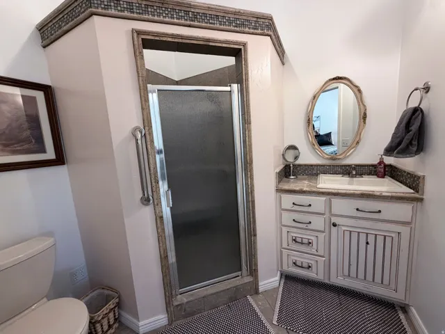 Bathroom with vanity, a stall shower, and light tile patterned floors