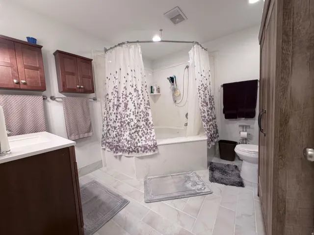 Full bath featuring shower / bath combination with curtain and vanity