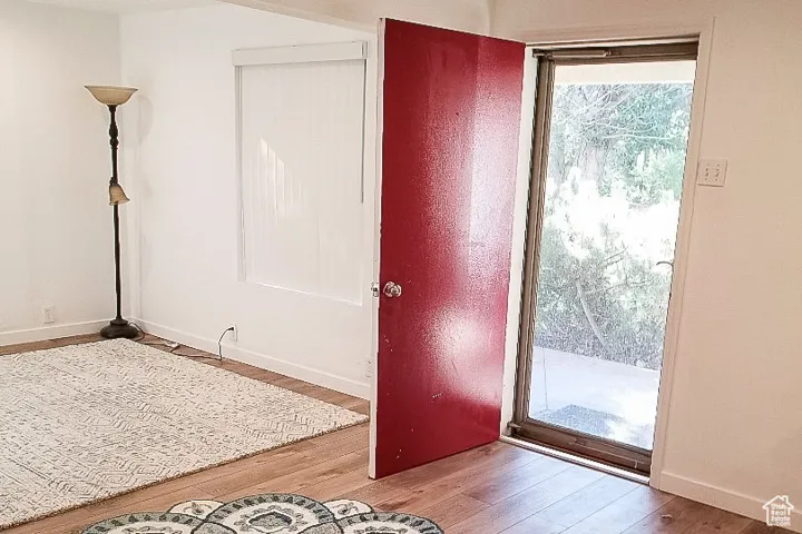 Doorway to outside with wood finished floors and baseboards