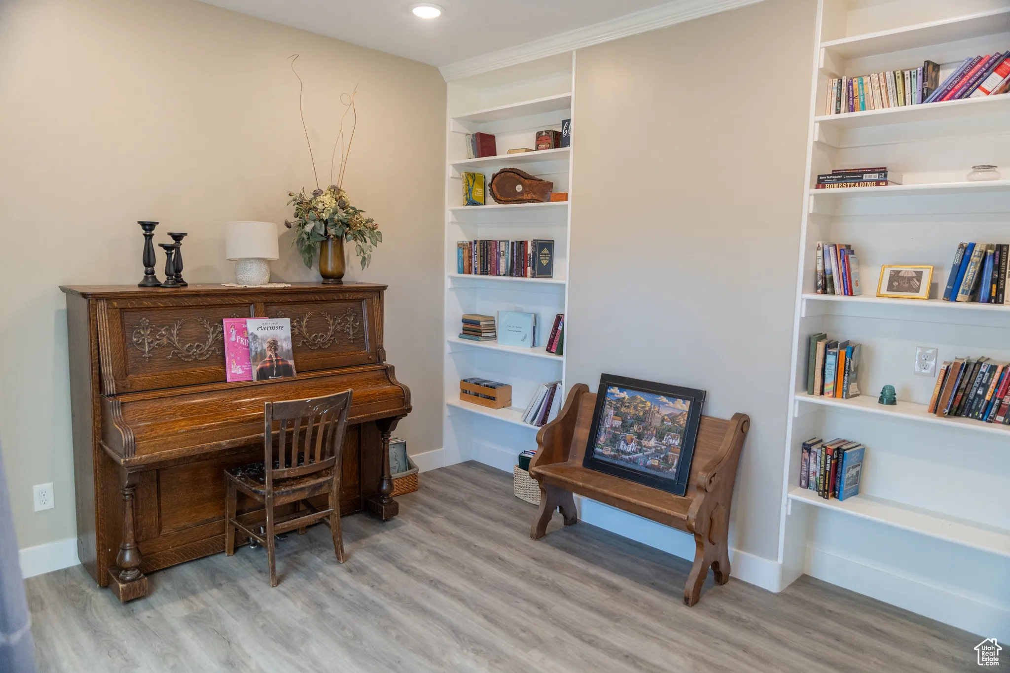 Living area featuring built in shelves and light wood-style floors