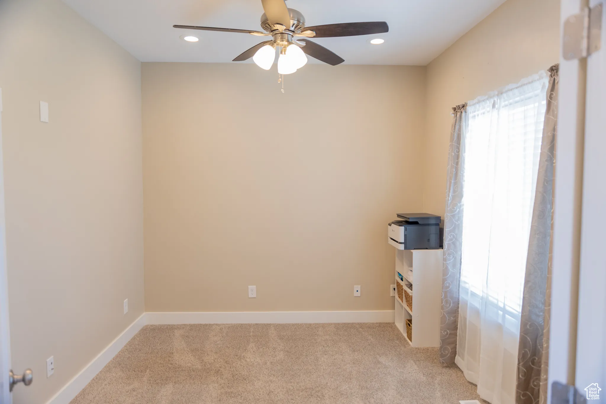 Unfurnished office featuring light colored carpet, a ceiling fan, and recessed lighting