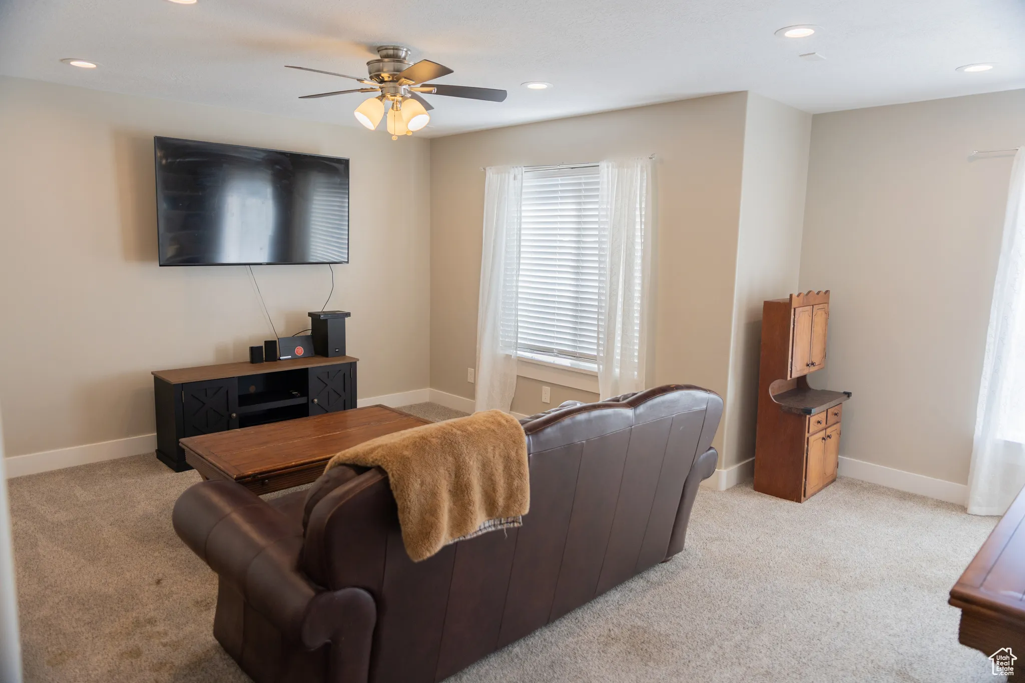 Living area featuring recessed lighting, light carpet, and ceiling fan