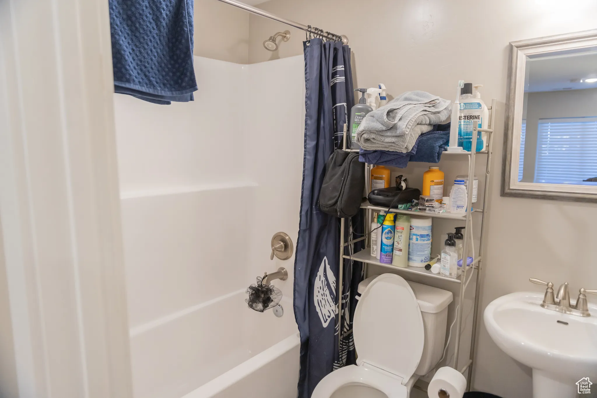 Bathroom featuring shower / tub combo with curtain and toilet