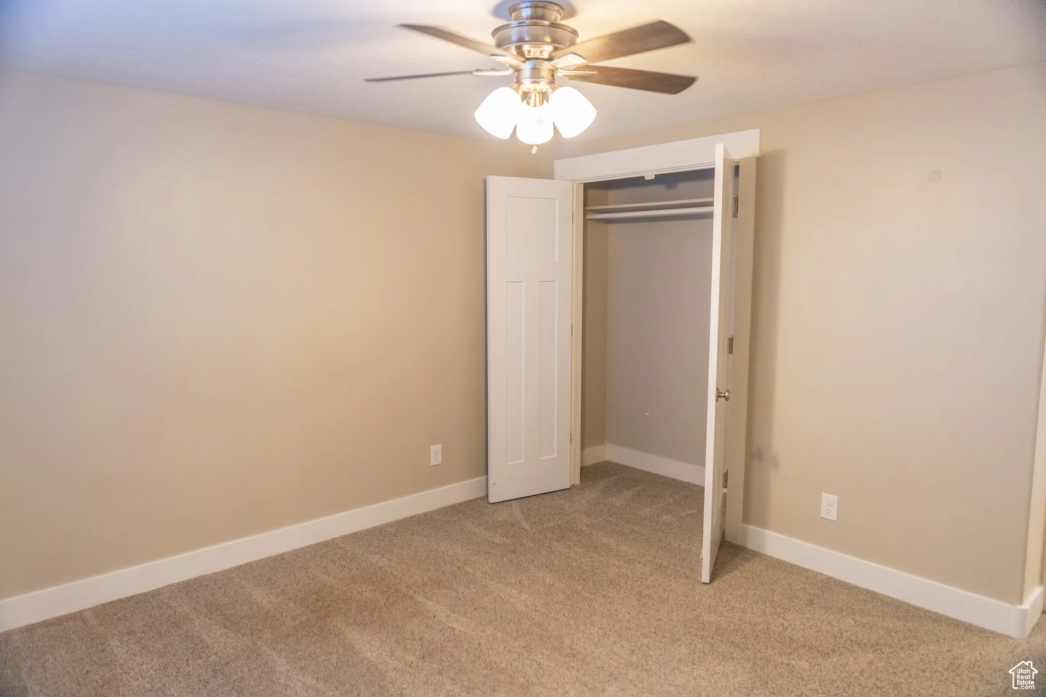 Basement apartment Master bedroom with colored carpet, a ceiling fan, and a closet