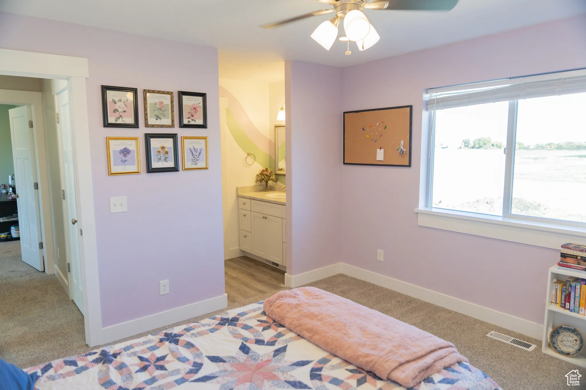 Bedroom with light colored carpet, ensuite bath, and a ceiling fan