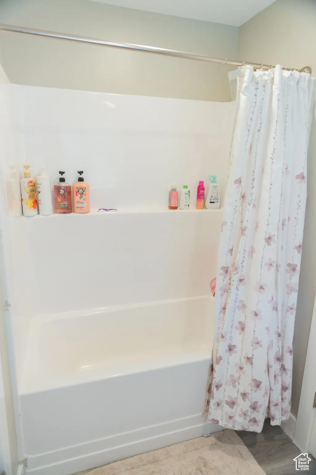 Bathroom featuring light wood-style floors and shower / tub combo with curtain