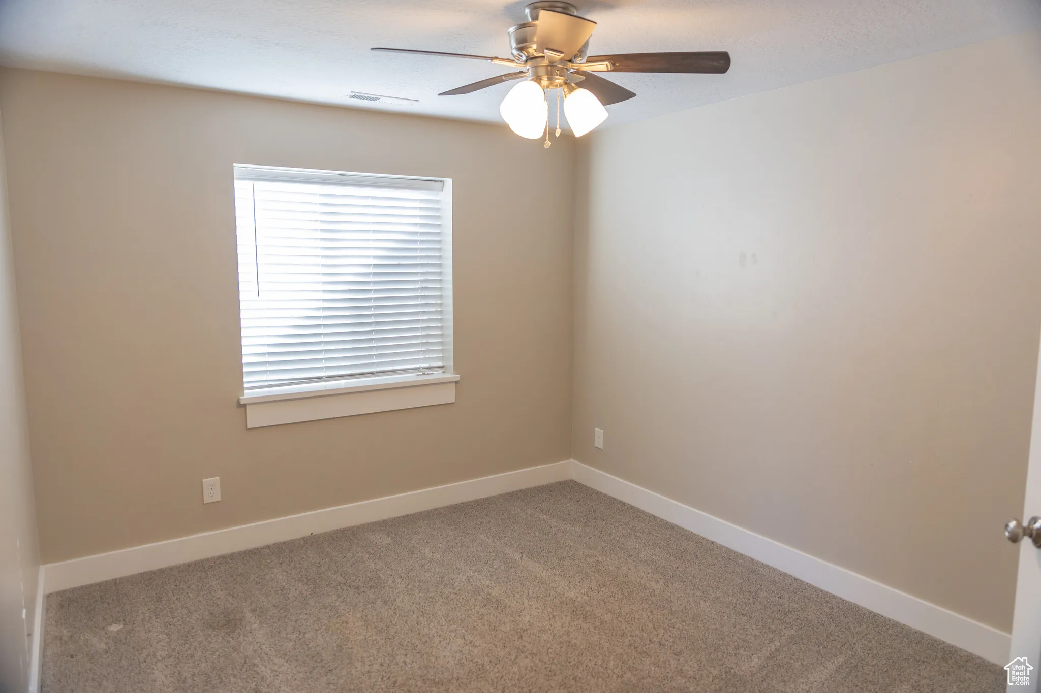 Basement apartment second bedroom with ceiling fan and a textured ceiling