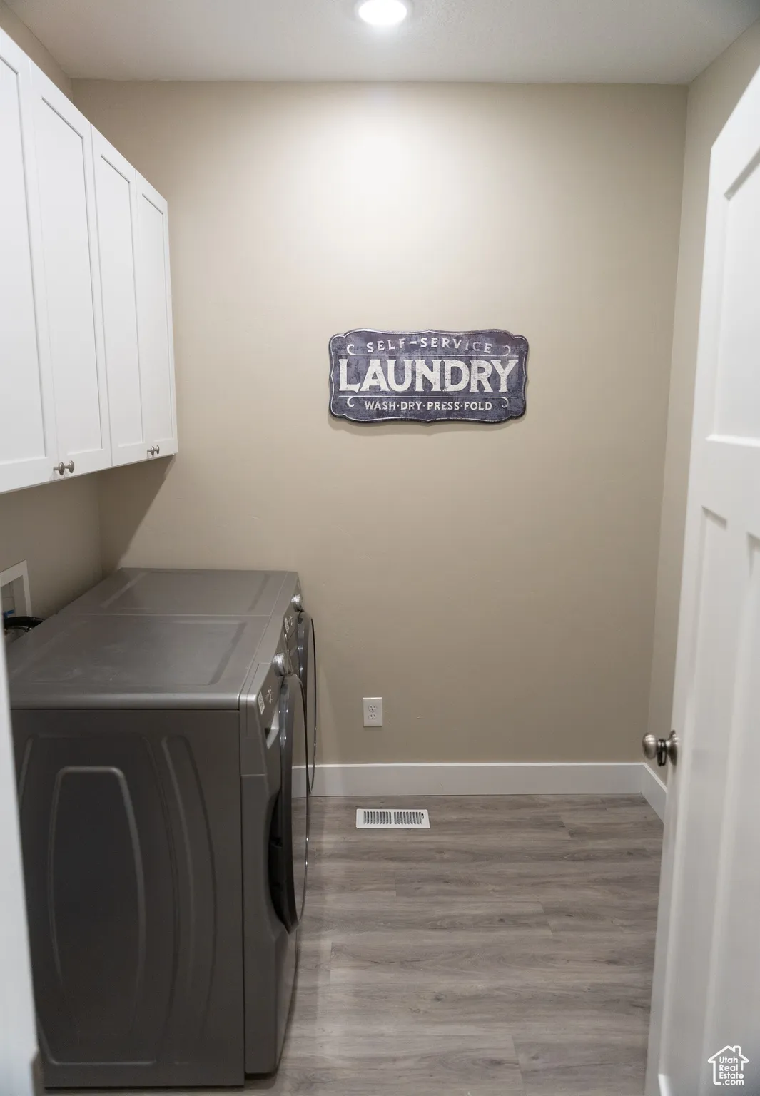 Laundry room featuring light wood-style floors, washer and clothes dryer, cabinet space, and recessed lighting