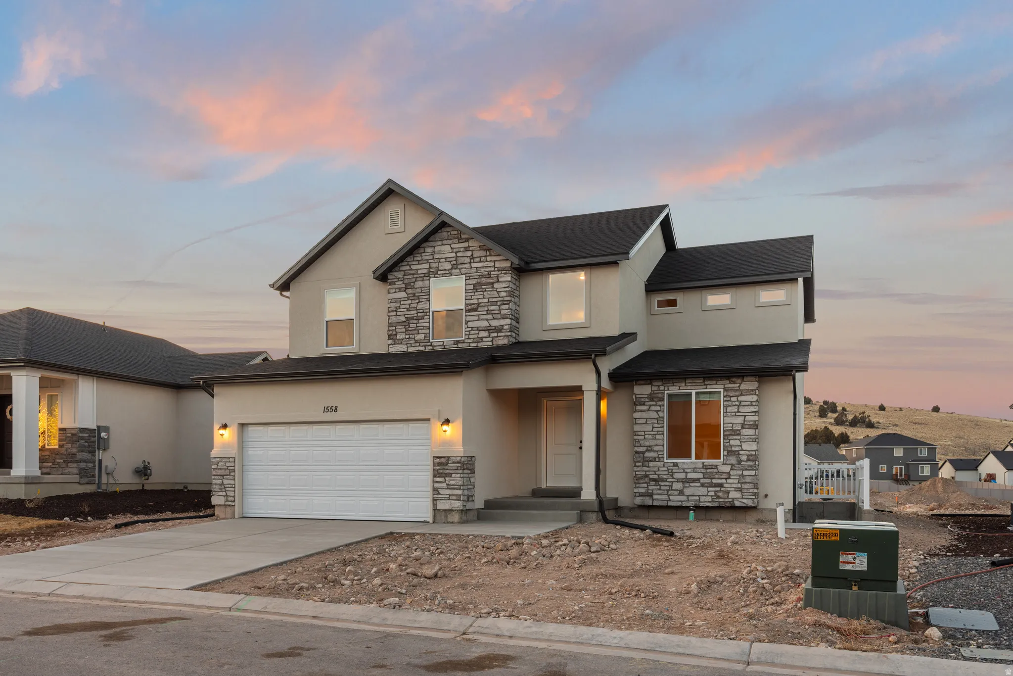 Traditional-style house featuring stone siding, stucco siding, concrete driveway, and a garage
