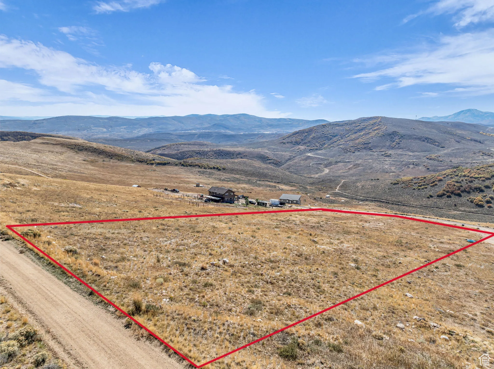 Overview of rural landscape with a mountainous background and property parcel outlined