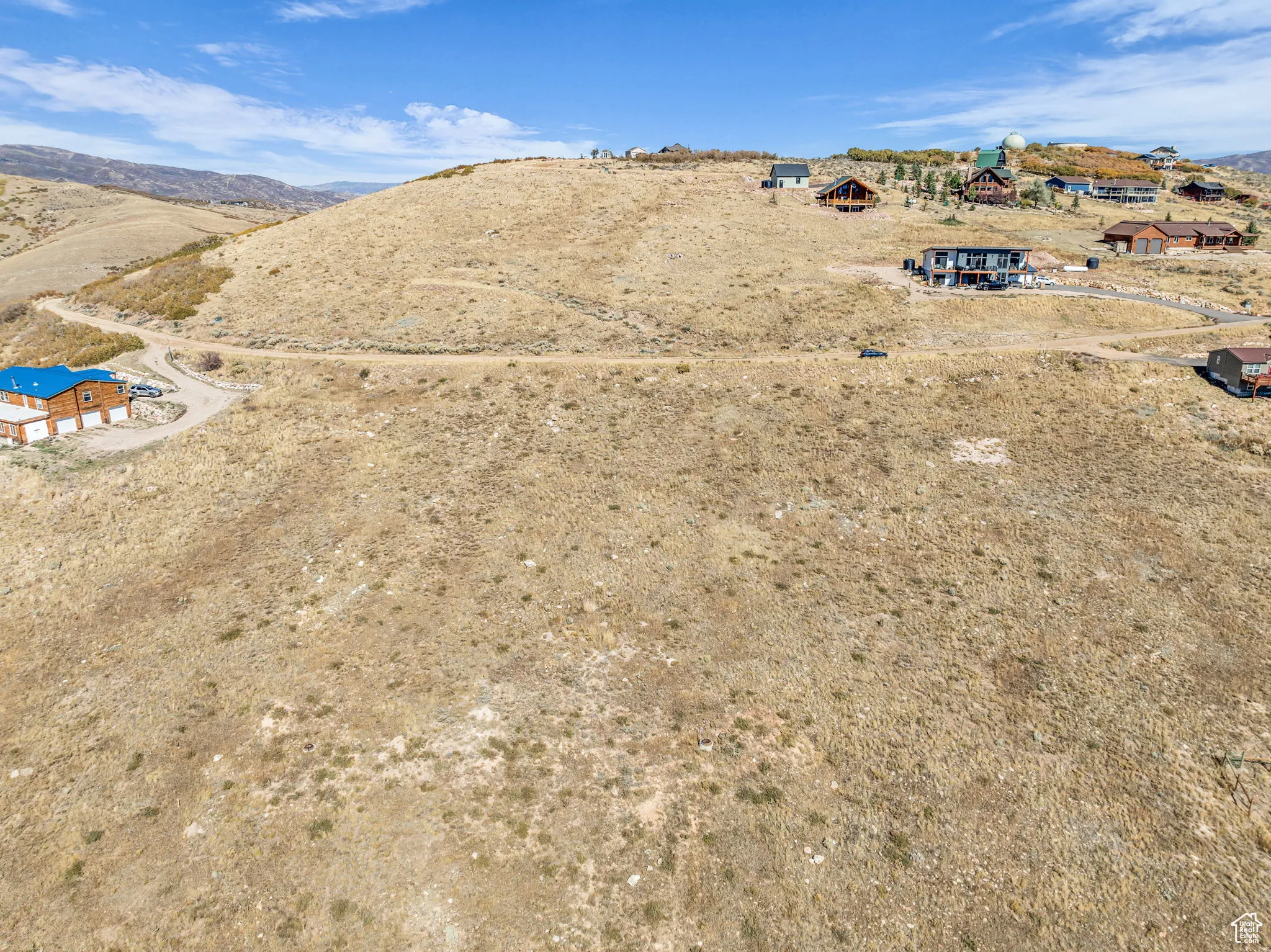 Aerial view of property and surrounding area featuring a mountain backdrop