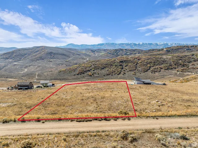 Overview of rural landscape featuring a mountain backdrop and property boundaries highlighted