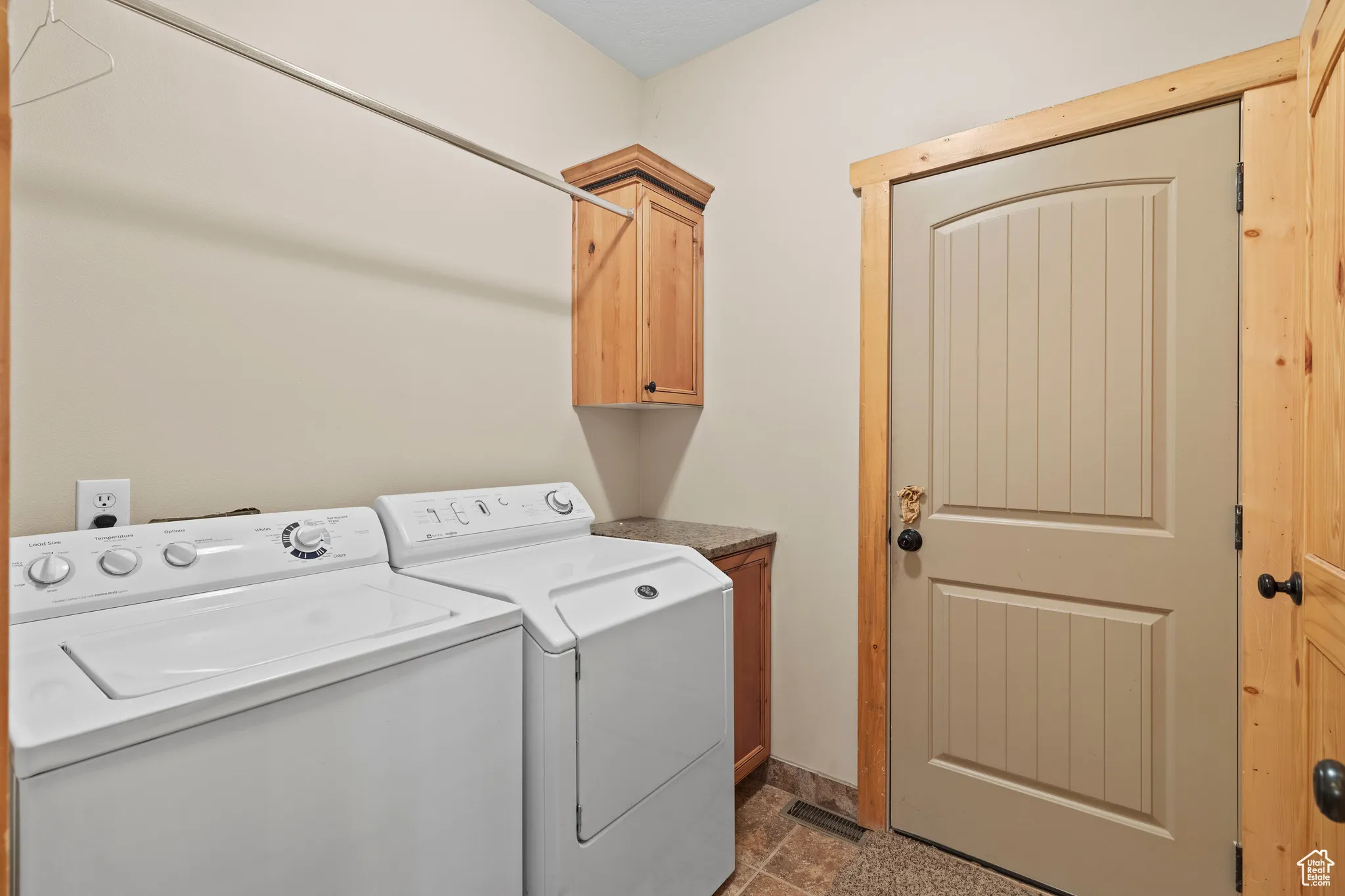 Laundry room with independent washer and dryer and cabinet space