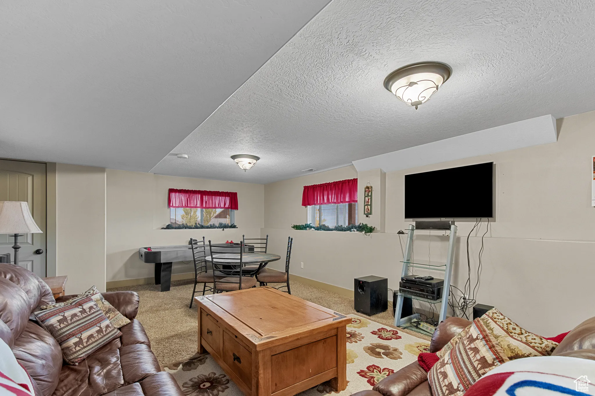 Carpeted living room featuring a textured ceiling and baseboards
