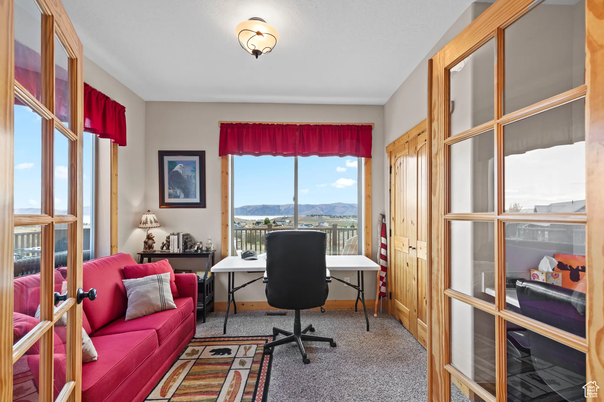 Carpeted office featuring a mountain view and french doors