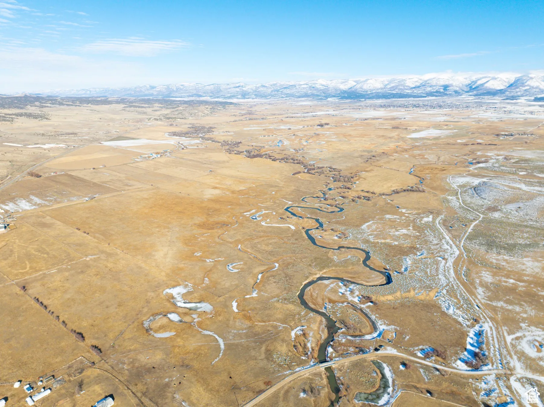 Aerial overview of property's location with rural landscape and a mountainous background