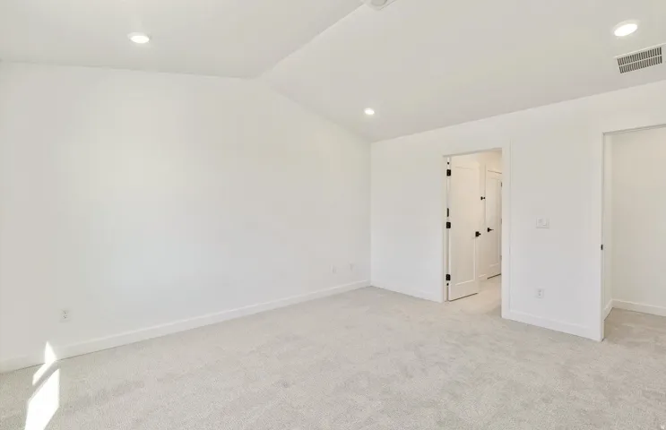 Unfurnished room featuring light colored carpet, recessed lighting, and vaulted ceiling