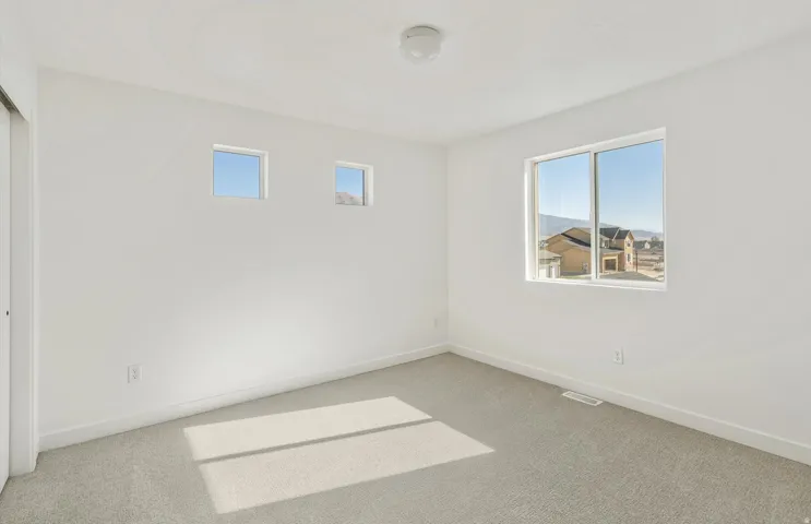 Unfurnished room with healthy amount of natural light and carpet