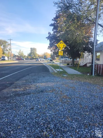 View of asphalt street featuring sidewalks and traffic signs