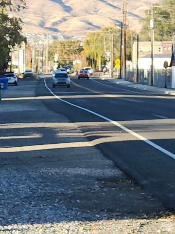 View of asphalt street featuring a mountain view and curbs