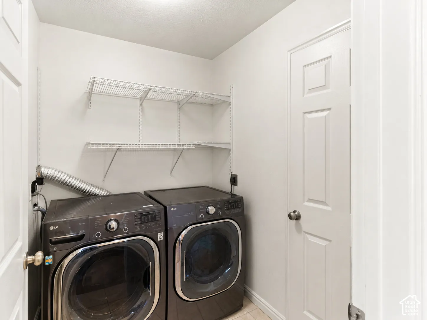 Laundry space featuring white walls, a six-panel interior door, and adjustable wall-mounted wire shelving