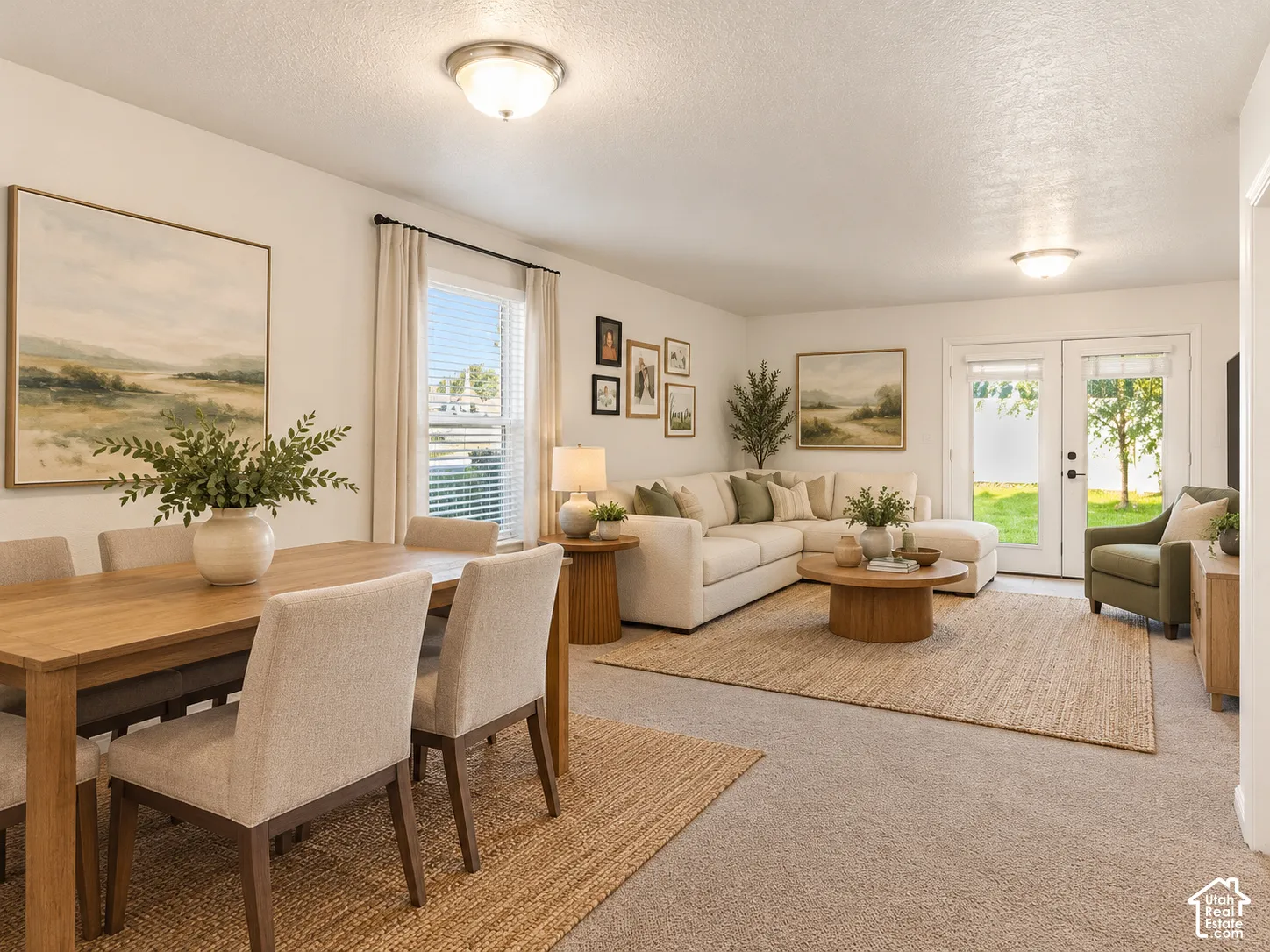 Open-concept area featuring neutral carpeting, flush-mount ceiling lighting, a single-hung window, and glass-paned double doors with exterior access