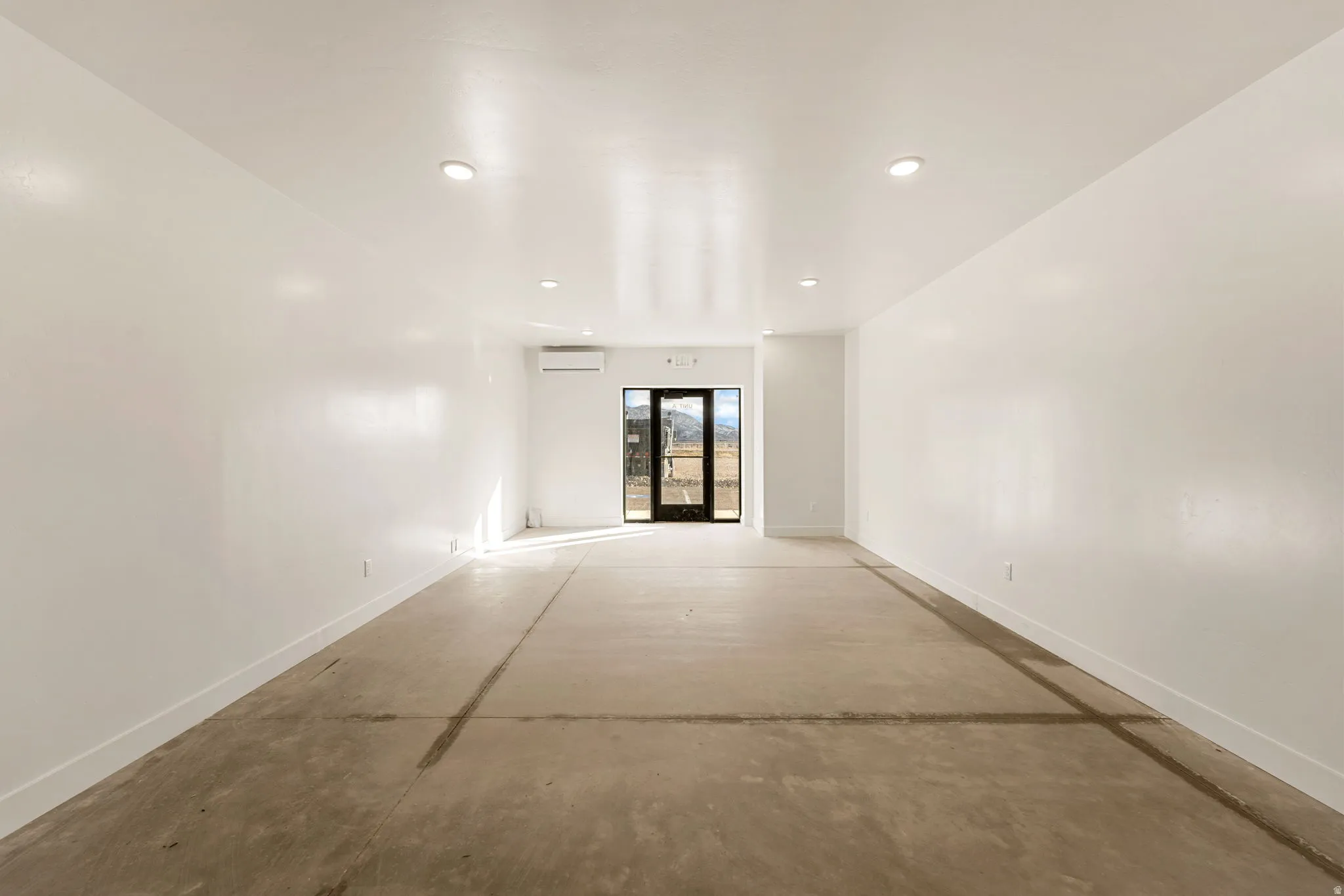 Spare room with concrete flooring and recessed lighting
